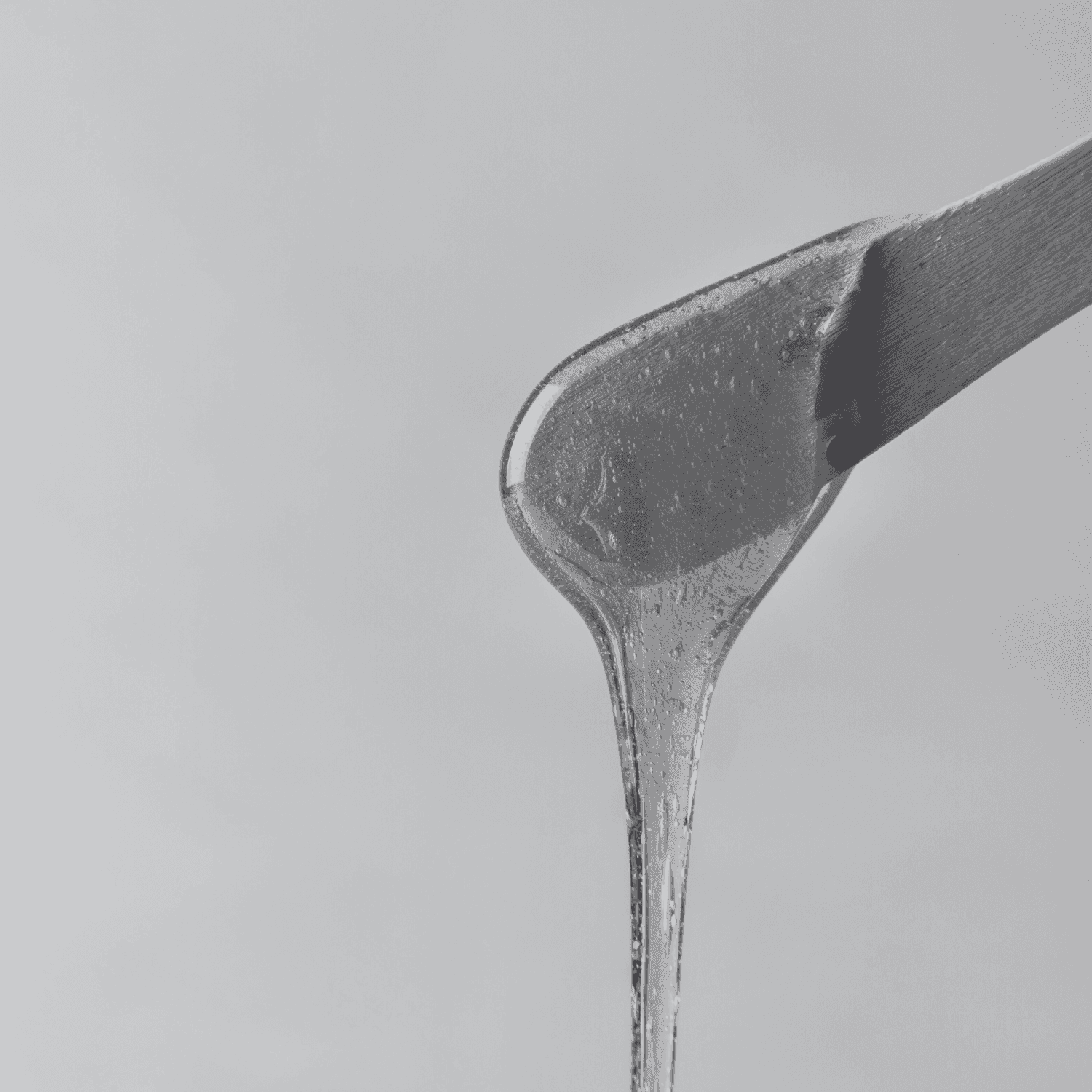 Gel being spread with a metal spatula, highlighted against a light gray background.